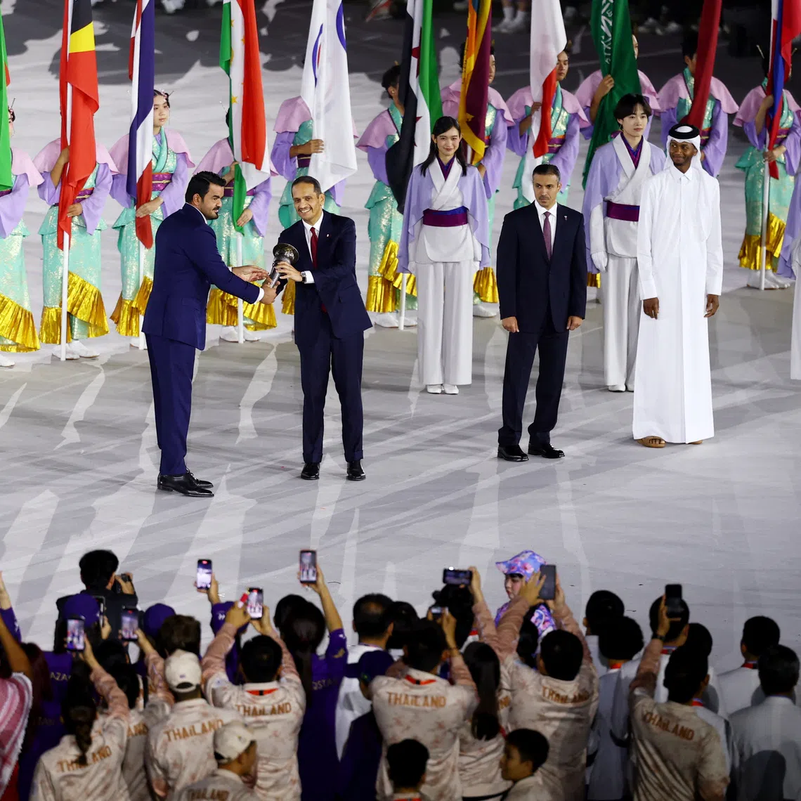Asian Games - Aichi-Nagoya 2026 - Closing Ceremony - Paloma Mizuho Stadium, Nagoya, Japan - October 4, 2026 OCA president Sheikh Joaan bin Hamad Al Thani passes on the torch of the first Asian Games to Qatar's Prime Minister Sheikh Mohammed bin Abdulrahman Al Thani during the closing ceremony REUTERS/Edgar Su