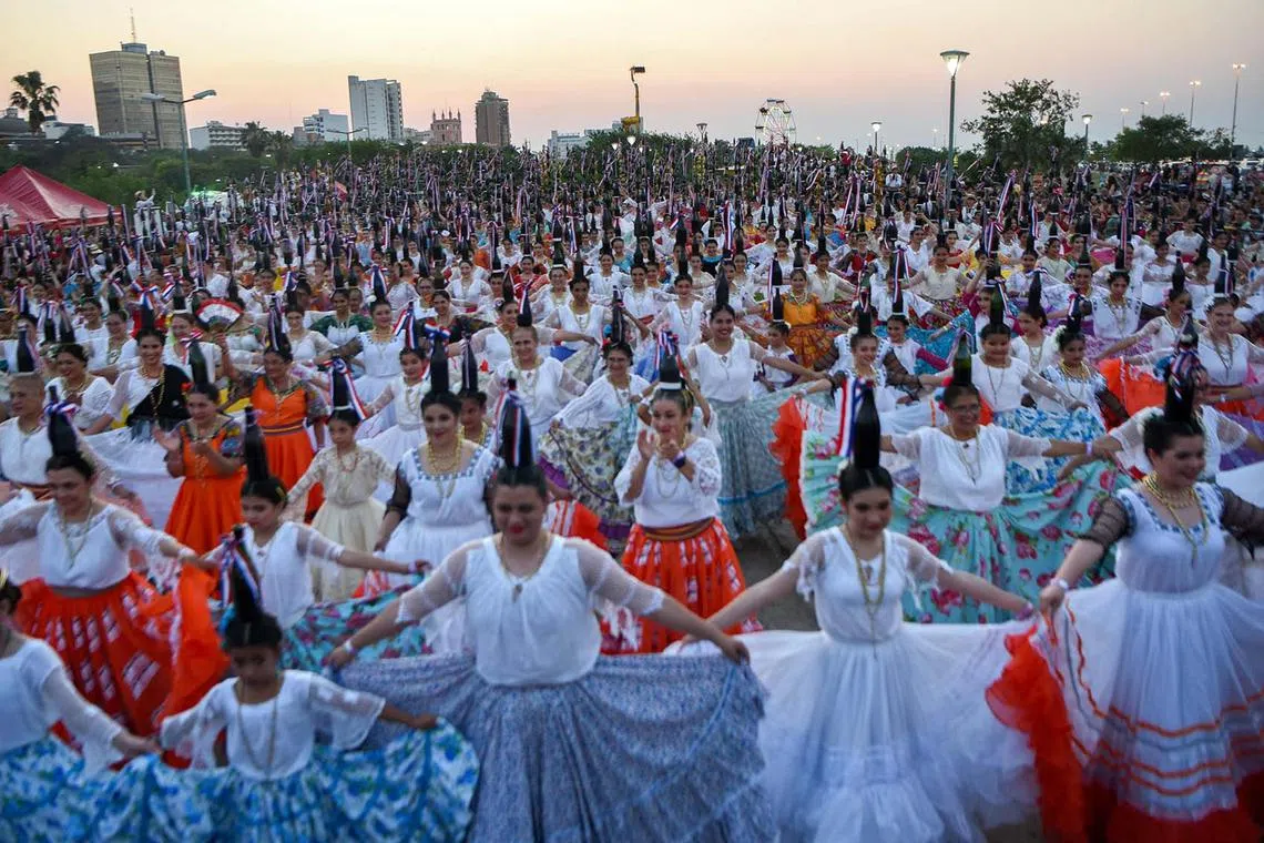 "Bottle dancers," a Paraguayan traditional folk dance in which performers dance with glass bottles balanced on their heads, attempt to set a record on the first edition of the National Day of the Bottle Women, at the Bicentennial Park in Asuncion on Sept 17. Paraguay obtained an Official World Record when 580 dancers balanced 2,200 bottles on their heads at the same time. 