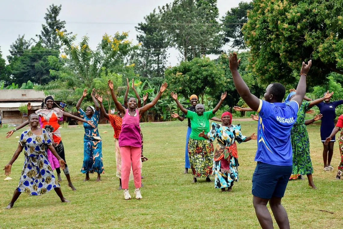 FILE PHOTO: Fitness coach Aaron Kusasira guides elderly women as they take part in community-led fitness drills session that combines yoga, aerobics, and cricket drills to combat non-communicable diseases (NCDs), on a playing field in Kivubuka village, in Jinja District, Eastern Uganda, July 12, 2025. REUTERS/Abubaker Lubowa/File Photo