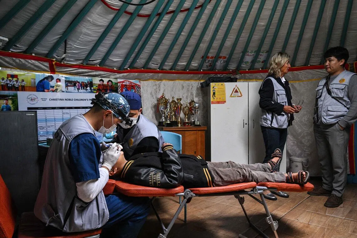 A dentist checks a child’s teeth at a mobile dental clinic inside a traditional Mongolian ger in Ulaanbaatar.