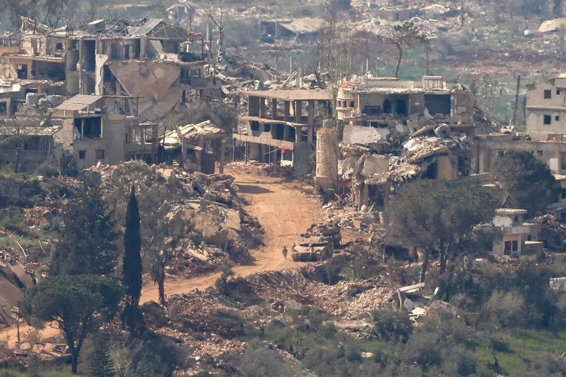 Israeli tanks and military vehicles driving along a road between destroyed houses in southern Lebanon, near the border with Israel, on April 25.