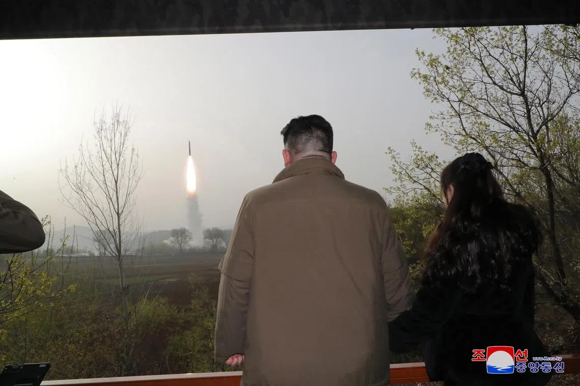A photo released by the official North Korean Central News Agency (KCNA) shows North Korean leader Kim Jong Un (L) and his daughter Kim Ju Ae observing the test firing of a new solid-fuel Hwasong-18 intercontinental ballistic missile (ICBM) at an undisclosed location in North Korea on Thursday. 