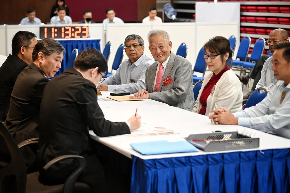 Ng Kok Song submitting his nomination papers to the returning officer in the nomination hall.
