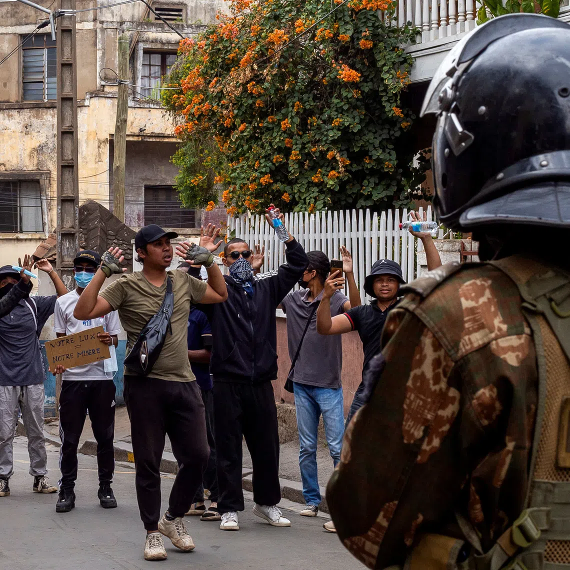 Protesters gesture in front of riot police officers during a demonstration against frequent power outages and water shortages, in the capital Antananarivo, Madagascar, October 1, 2025. REUTERS/Zo Andrianjafy