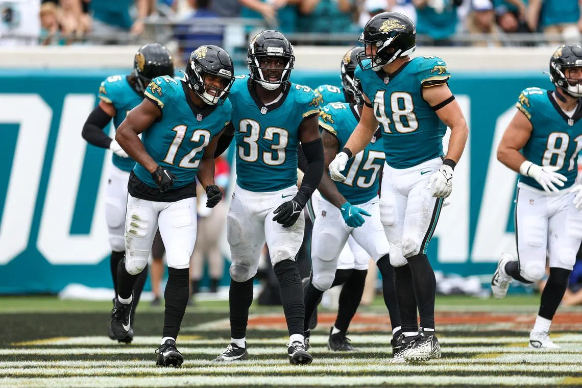 FILE PHOTO: Oct 6, 2024; Jacksonville, Florida, USA; Jacksonville Jaguars wide receiver Devin Duvernay (12) and linebacker Devin Lloyd (33) celebrate after a play against the Indianapolis Colts in the third quarter at EverBank Stadium. Mandatory Credit: Nathan Ray Seebeck-Imagn Images/File Photo