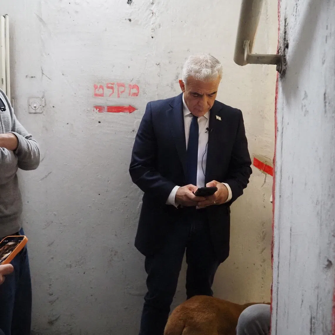 Israeli opposition leader Yair Lapid uses his phone in a shelter as sirens sound after missiles were launched towards Israel from Iran following strikes by Israel and the U.S. on Iran, in Tel Aviv, Israel February 28, 2026. REUTERS/Alexander Cornwell