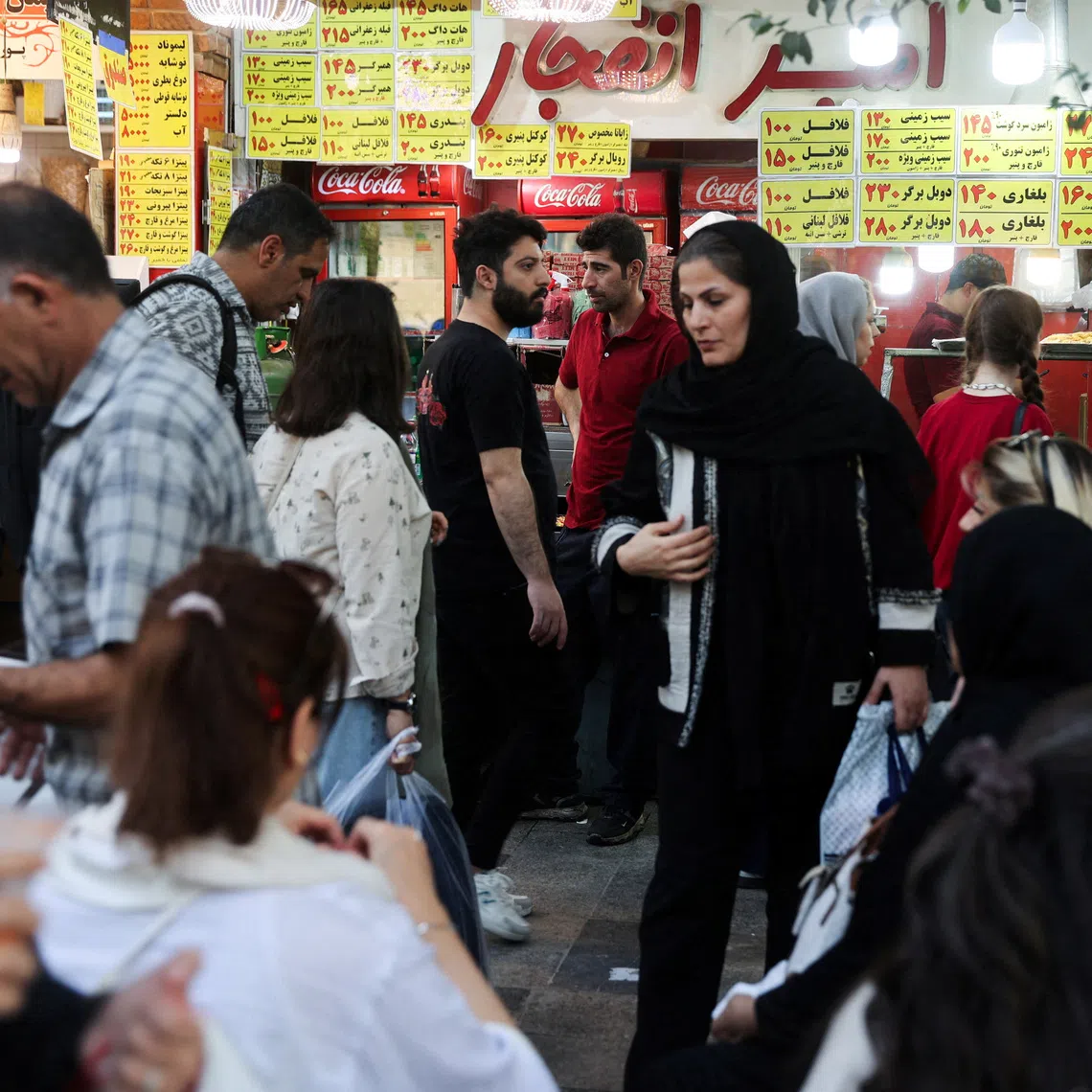 FILE PHOTO: Iranian people walk at the Tehran Bazaar after the approval of the bill to remove four zeros from the national currency, in Tehran, Iran, October 5, 2025. Majid Asgaripour/WANA (West Asia News Agency) via REUTERS/File Photo