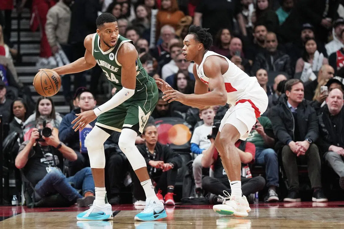 Milwaukee Bucks forward Giannis Antetokounmpo controls the ball as Toronto Raptors forward Scottie Barnes defends during the third quarter at Scotiabank Arena.