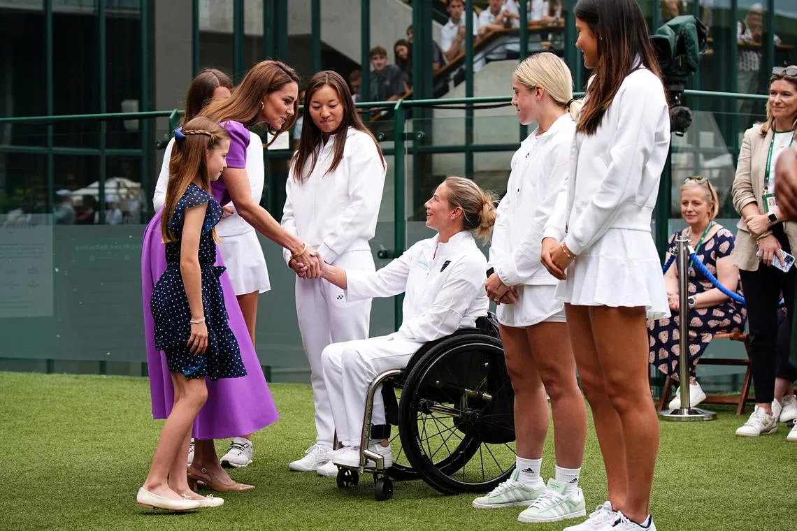 Britain's Princess Charlotte of Wales (left) making a "pinky promise" with wheelchair tennis Paralympian Lucy Shuker  on July 14.