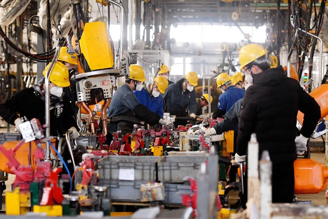 Employees work at an assembly line of a Wuling Motors factory in Qingdao, in China's eastern Shandong province on March 1, 2023. (Photo by AFP) / China OUT