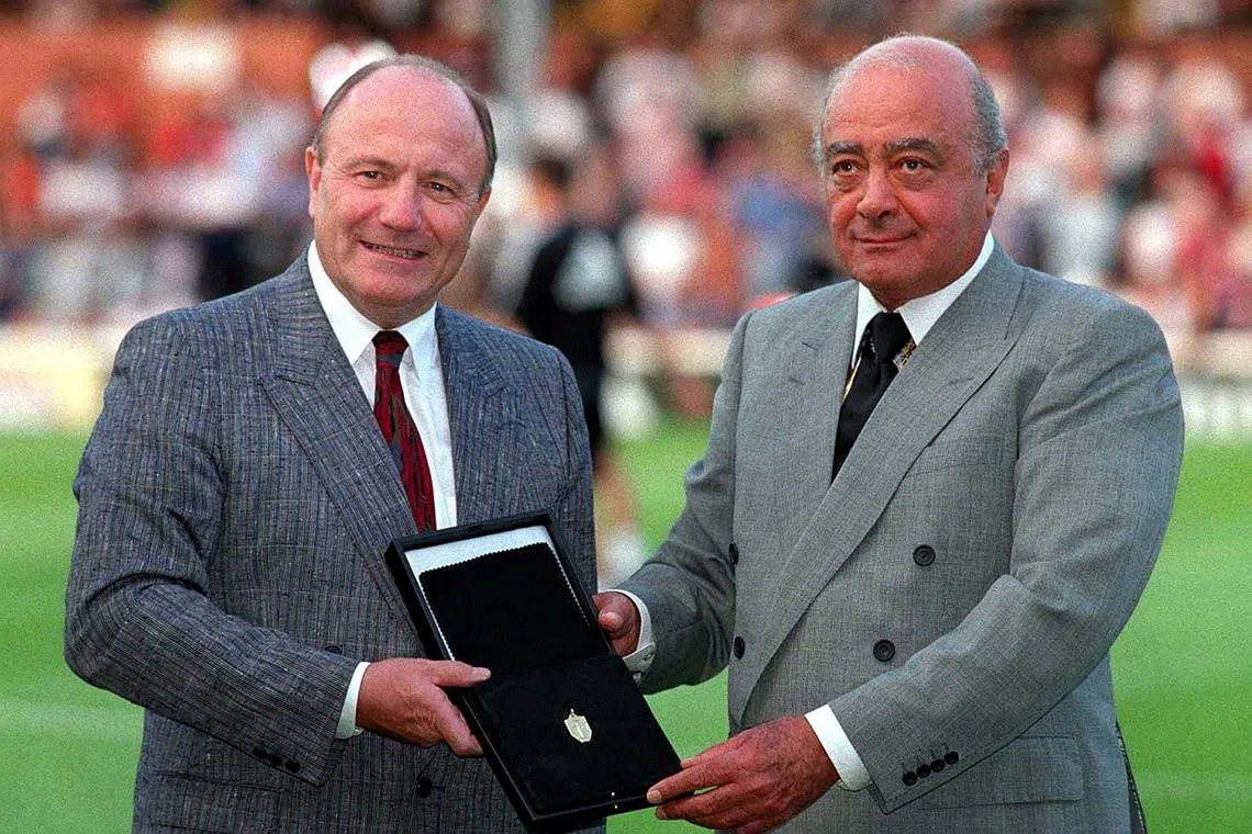 George Cohen (left) handing his 1966 World Cup winner's medal to Fulham chairman Mohammed Al Fayed in 1998.
