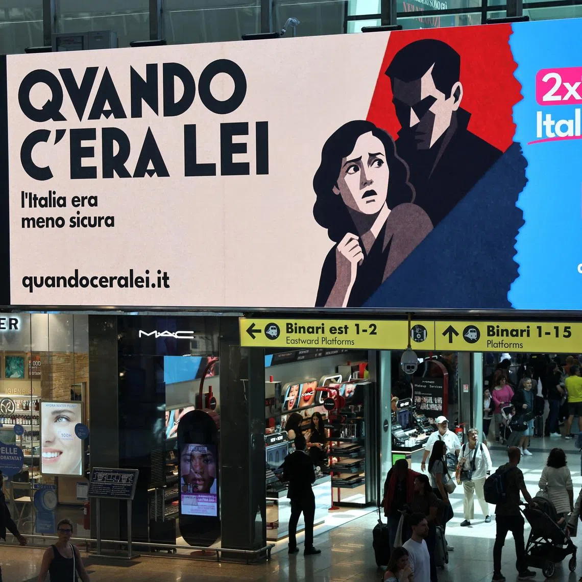 People walk past an advertisement, commissioned by Italia Viva at Roma Termini railway station, referring to Italian Prime Minister Giorgia Meloni, reading in English, and featuring imagery and typography reminiscent of Italian fascist-era propaganda from the 1930s, in Rome, Italy, May 22, 2026. 