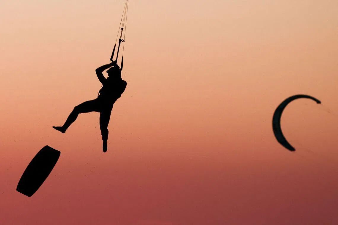 A kitesurfer soaring into the air above sea as the sun sets in Marseille, south-eastern France on March 29, 2026. 