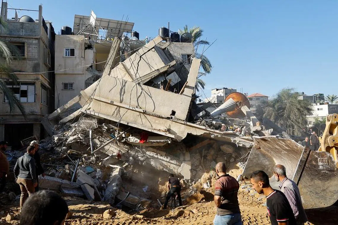 Palestinians search for casualties at the site of an Israeli strike on a house, in Khan Younis, in the southern Gaza Strip, October 21, 2023. REUTERS/Ibraheem Abu Mustafa