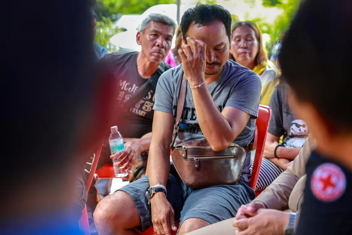 Komsan Prachan, 40, who lost his wife and two children when a Cambodia's artillery shell slammed into the gas station and destroyed the attached 7-Eleven convenience store, reacts during a meeting with officials at a temple in Sisaket province, Thailand, July 26, 2025. REUTERS/Athit Perawongmetha