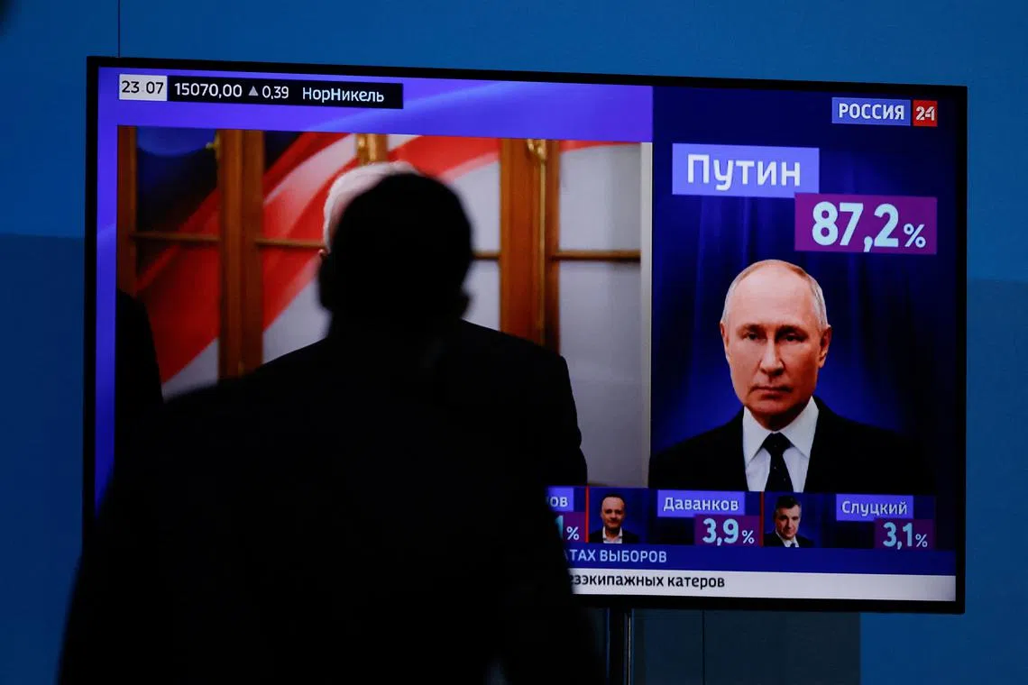 A man watches a TV broadcasting news on the results of Russian incumbent President and presidential candidate Vladimir Putin, on the final day of the presidential election in Moscow, Russia, March 17, 2024. REUTERS/Maxim Shemetov