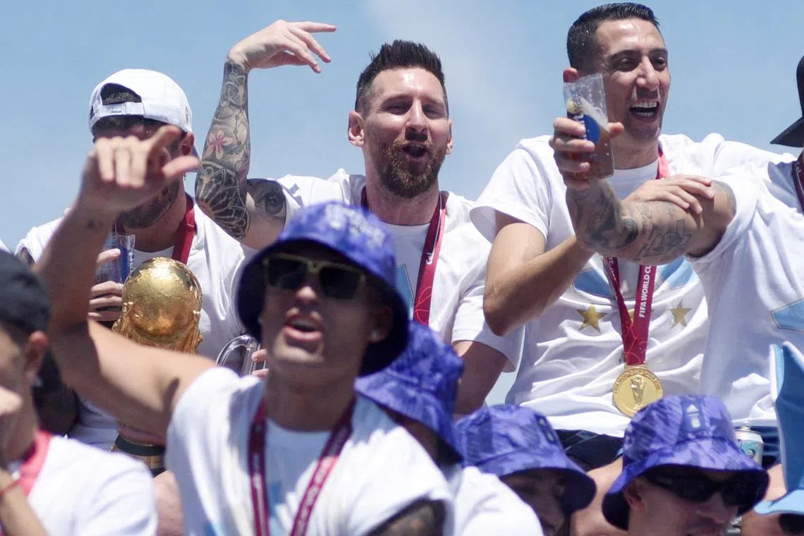 Argentina's Lionel Messi, Angel Di Maria and teammates celebrate on the bus with the World Cup trophy during the victory parade, Dec 20, 2022.