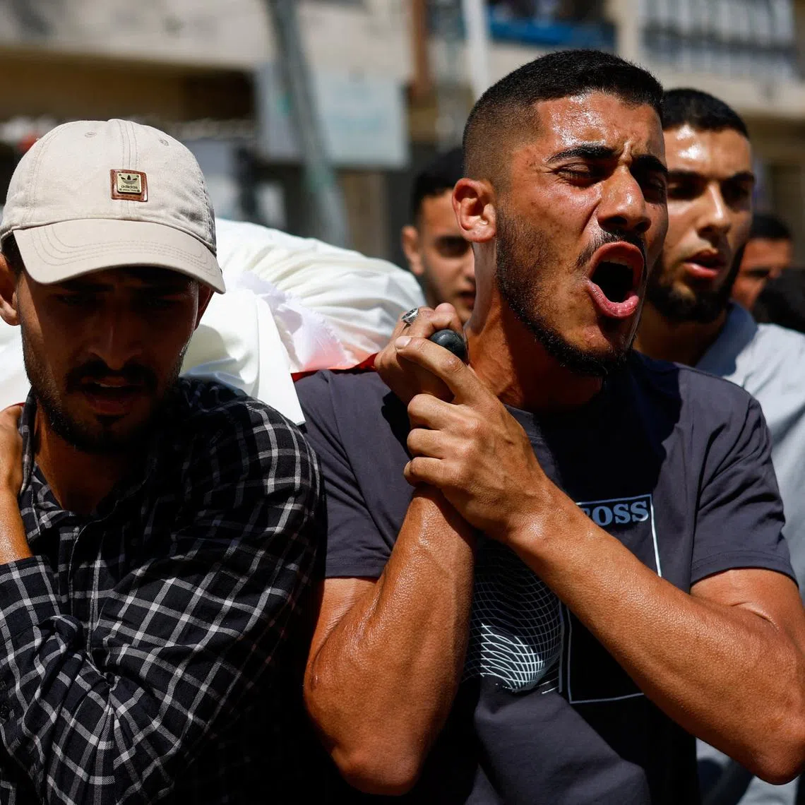 People carry bodies identified by mourners as Hamas' military wing commander Mohammad Odeh, who was killed in an Israeli strike on Tuesday, and his wife and children, during a funeral, in Gaza City, May 27, 2026. REUTERS/Mahmoud Issa