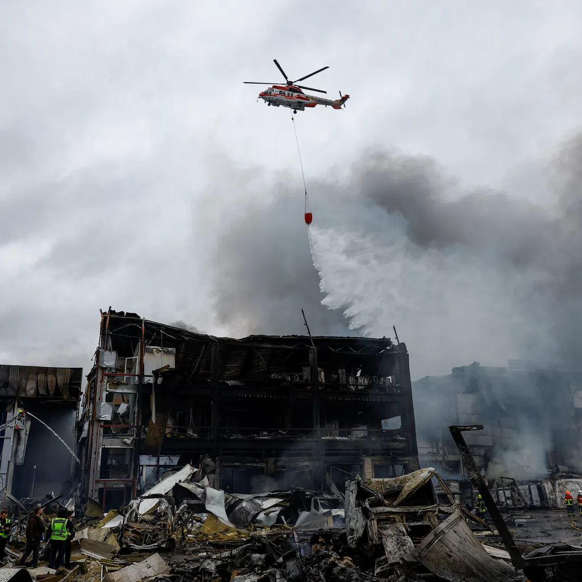A firefighting helicopter drops water over food warehouses hit by an overnight Russian missile strike, amid Russia’s attack on Ukraine, in Kyiv, Ukraine October 25, 2025. REUTERS/Valentyn Ogirenko