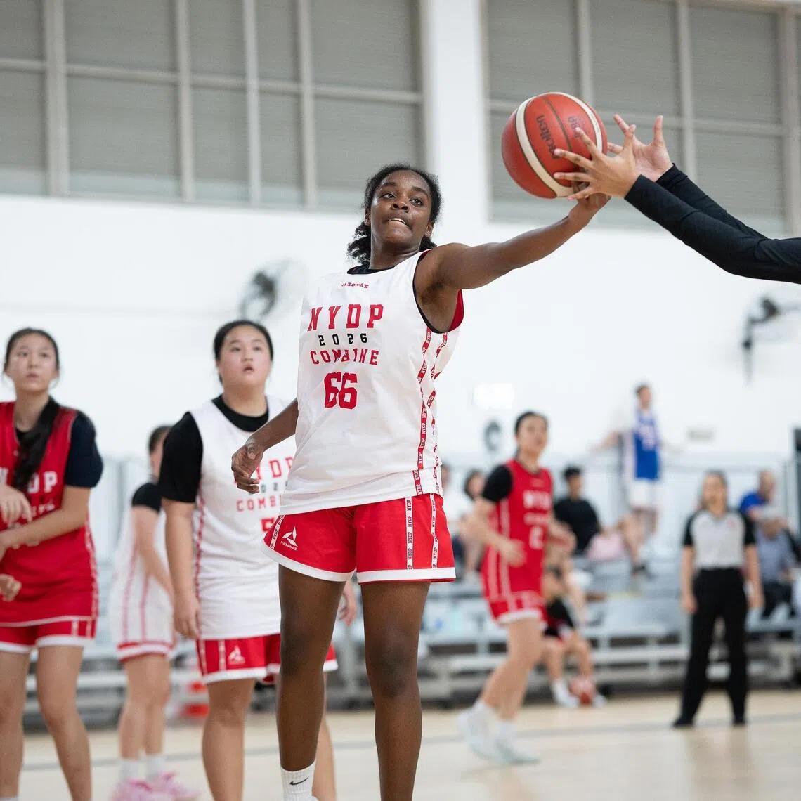 Elessa Angel Emily (middle) transferred from Yishun Secondary School to the Singapore Sports School (SSP) in 2026 and is part of both NYDP U19 and 3x3 basketball programmes.
Credit: Sport Singapore 
caption: Elessa Angel Emily (middle) transferred from Yishun Secondary School to the Singapore Sports School (SSP) in 2026 and is part of both NYDP U19 and 3x3 basketball programmes.