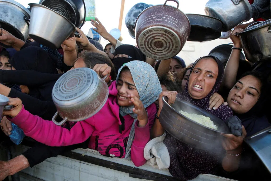 FILE PHOTO: Palestinians gather to receive food cooked by a charity kitchen, amid a hunger crisis, as the Israel-Gaza conflict continues, in Khan Younis in the southern Gaza Strip, November 19, 2024. REUTERS/Hatem Khaled/File Photo