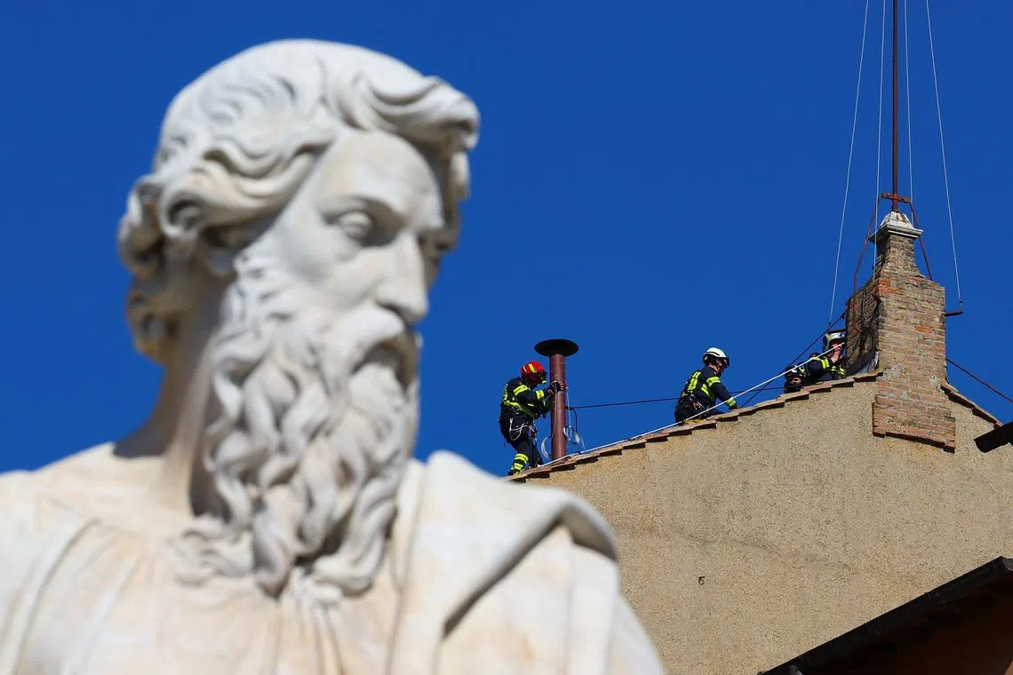 Firefighters work to set a chimney on the roof of the Sistine Chapel, ahead of the conclave, at the Vatican May 2, 2025. REUTERS/Guglielmo Mangiapane
