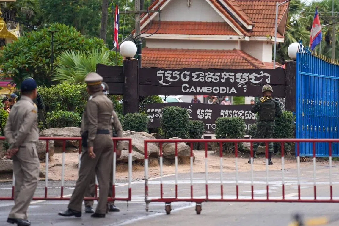 Thai police officers and a soldier standing guard at the Chong Jom border checkpoint along the border between Thailand and Cambodia on June 11.