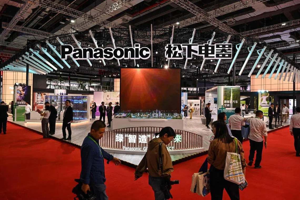 People walk next to the Panasonic stand at the 6th China International Import Expo (CIIE) in Shanghai on November 5, 2023.
