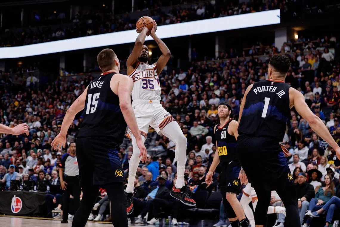 Phoenix Suns forward Kevin Durant attempting a shot against Denver Nuggets centre Nikola Jokic (No. 15) and forward Michael Porter Jr. in the fourth quarter at Ball Arena on March 27. Durant scored 30 points and grabbed 13 rebounds to lead his side to a 104-97 NBA victory.