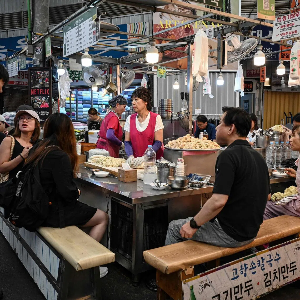People dine at a food stall at Gwangjang Market in Seoul.