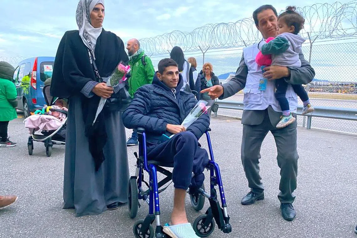 Geneva-based doctor Raouf Salti holds 17-month-old Zeina, next to 16-year-old Yussef and his mother who were evacuated from Gaza to Switzerland to receive medical treatment, at their arrival at Geneva airport, Switzerland, February 12, 2024.  REUTERS/Gabrielle Tetrault-Farber