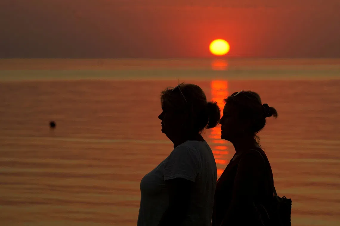 FILE PHOTO: People watch sunset on the seaside in Saulkrasti, Latvia August 27, 2022. REUTERS/Ints kalnins/File Photo