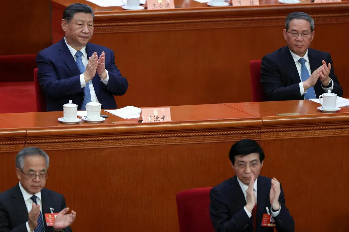 Chinese President Xi Jinping applauds next to Premier Li Qiang at the opening session of the Chinese People's Political Consultative Conference (CPPCC) at the Great Hall of the People in Beijing, China March 4, 2025. REUTERS/Florence Lo