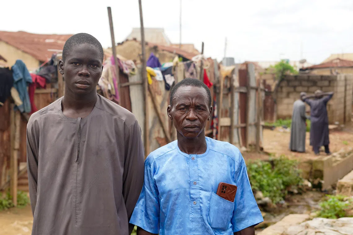 Adamu Isah, 22, a survivor, stands with his father at their home after returning from detention in Niger State, Nigeria, September 19, 2026. Isah recounted his experience following reports that 37 detained miners died while in the custody of the Nigeria Security and Civil Defence Corps. REUTERS/Ibrahim Ndamitso