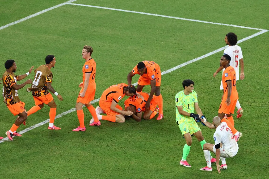 The Netherlands’ Cody Gakpo celebrates scoring their first goal against Mexico with teammates on June 29.