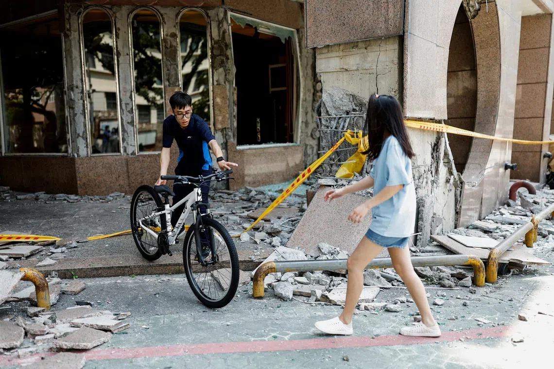 People move a bicycle from a bicycle store in a damaged building as they place it outside the building, following the earthquake, in Hualien, Taiwan, April 4, 2024. REUTERS/Carlos Garcia Rawlins/ File photo
