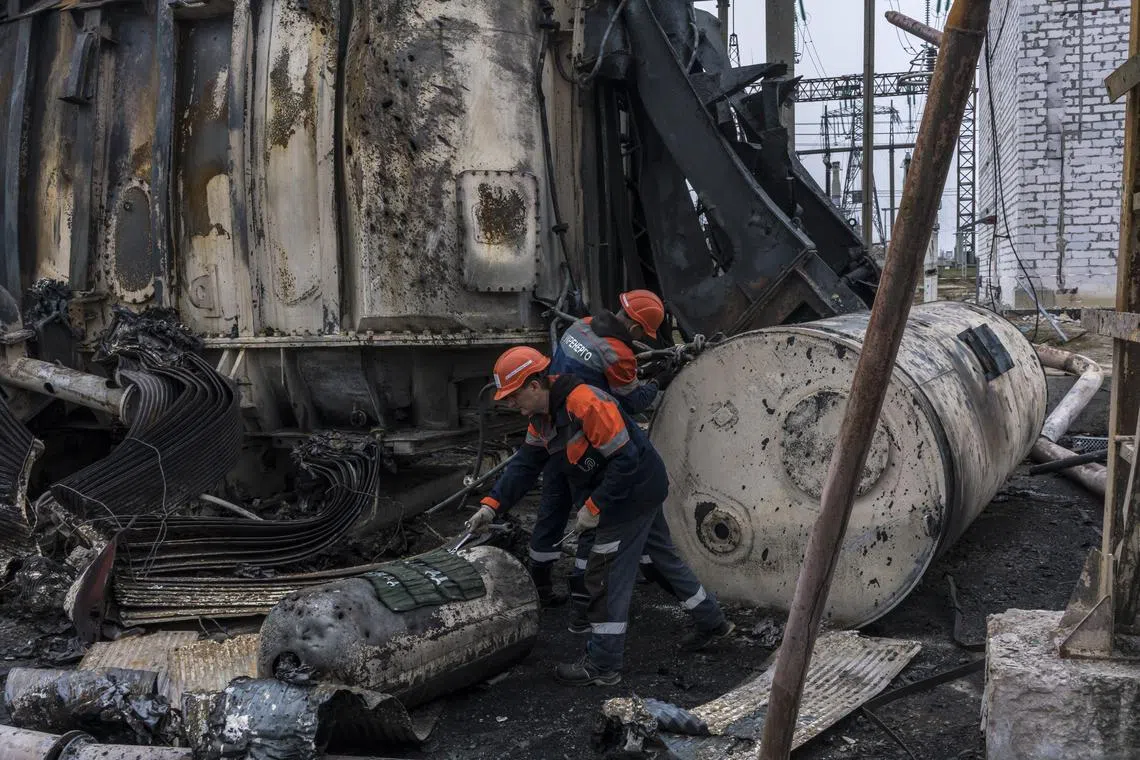 Employees with Ukrenergo, the energy company owned by the Ukrainian government, work to repair a transformer damaged by a Russian missile strike at a high-voltage electrical substation in central Ukraine on Nov 10, 2022. 