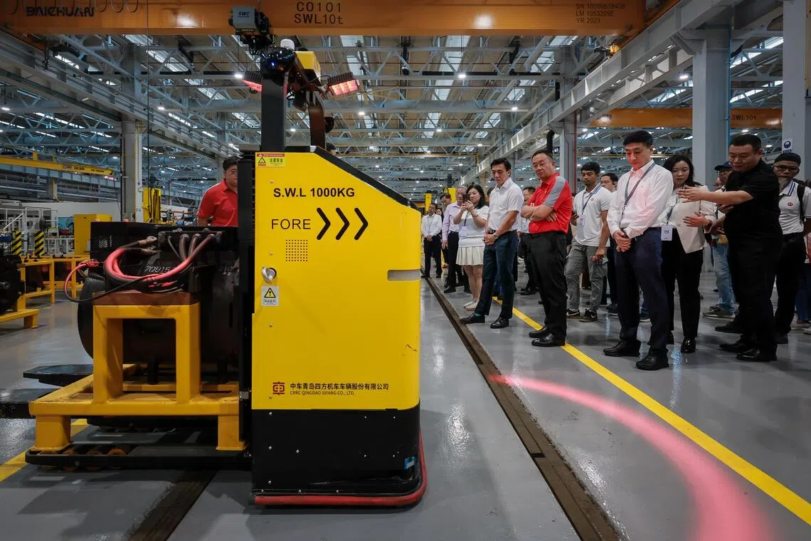 Acting Transport Minister Jeffrey Siow (in short-sleeved white shirt) observing an automated guided vehicle (AGV) at the launch of Depot 4.0 at Bishan Depot on Nov 21.