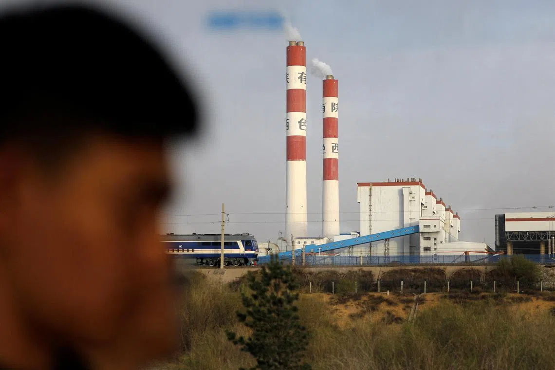 Smoke rising from chimneys is seen through a car window, during an organised media tour, in Shaanxi province, China, April 26, 2023. REUTERS/Tingshu Wang