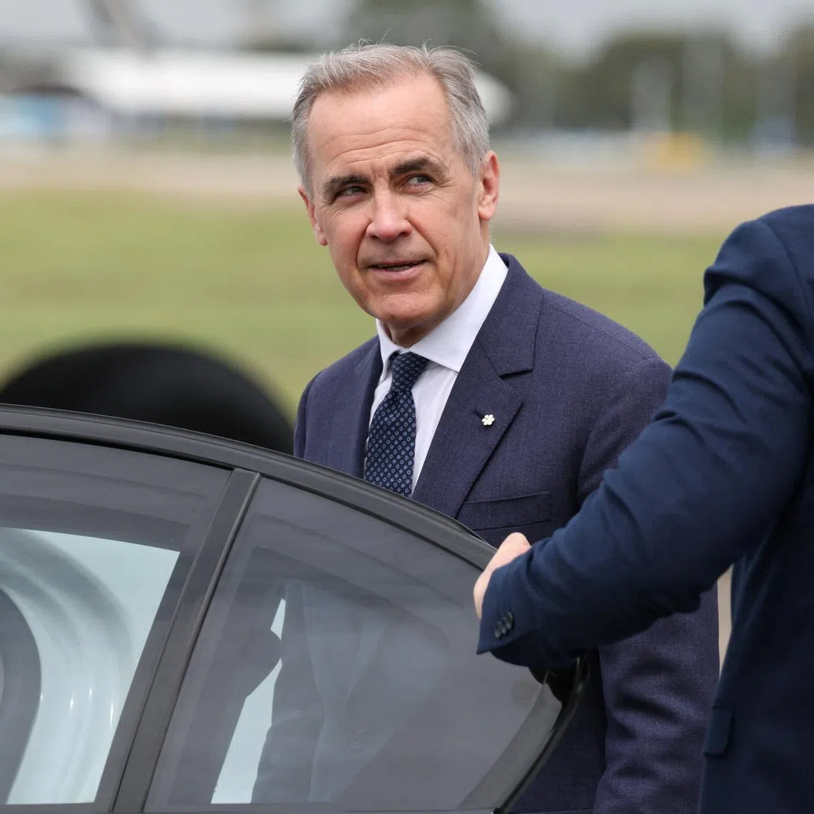 Canadian Prime Minister Mark Carney reacts as he enters a vehicle at Sydney Kingsford Smith Airport in Sydney, Australia, March 3, 2026. REUTERS/Hollie Adams