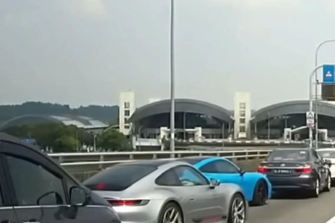 The grey Porsche is first seen crossing the double white line from the leftmost bus lane to the second left lane for cars.