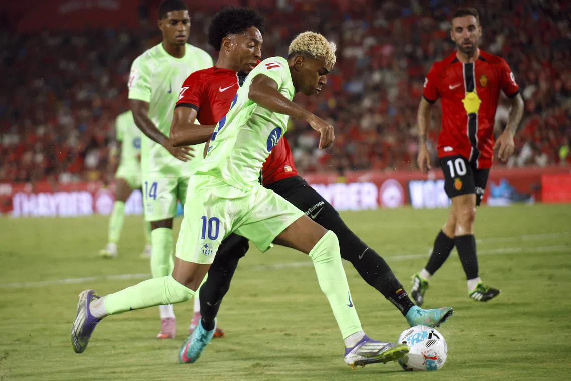 Soccer Football - LaLiga - RCD Mallorca v FC Barcelona - Estadi Mallorca Son Moix, Palma de Mallorca, Spain - August 16, 2025 FC Barcelona's Lamine Yamal in action with RCD Mallorca's Johan Mojica REUTERS/Francisco Ubilla