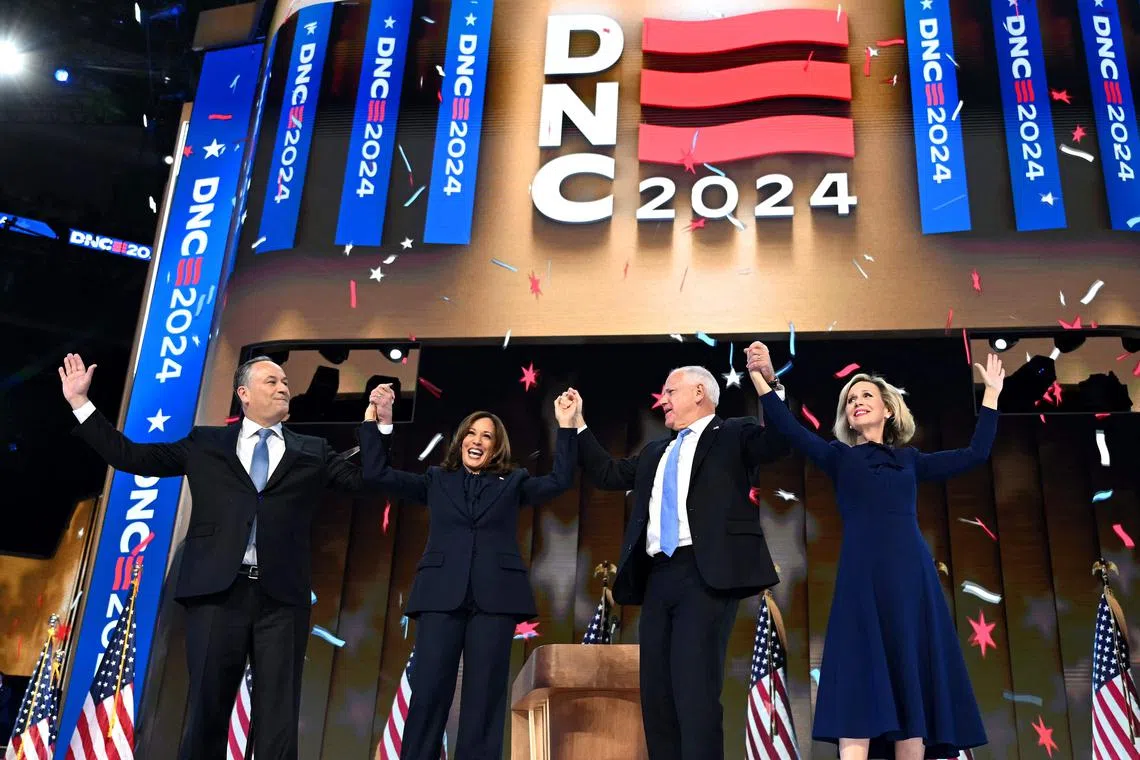 TOPSHOT - (L-R) US Second Gentleman Douglas Emhoff, US Vice President and 2024 Democratic presidential candidate Kamala Harris, Minnesota Governor and 2024 Democratic vice presidential candidate Tim Walz and Tim Walz's wife Gwen Walz hold hands at the end of the fourth and last day of the Democratic National Convention (DNC) at the United Center in Chicago, Illinois, on August 22, 2024. Vice President Kamala Harris will formally accept the party’s nomination for president today at the DNC which ran from August 19-22 in Chicago. (Photo by ANDREW CABALLERO-REYNOLDS / AFP)