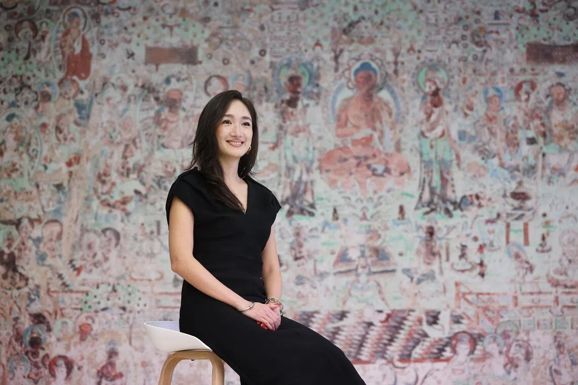 ACM curator Louise Lui in front of a replica of a Mogao Caves mural in Dunhuang, China.