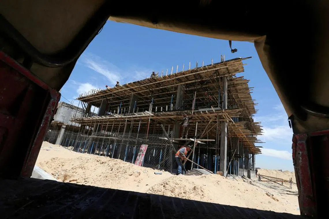 FILE PHOTO: Palestinian workers work on a Qatari-funded construction project in the southern Gaza Strip June 7, 2017. REUTERS/Ibraheem Abu Mustafa/File Photo