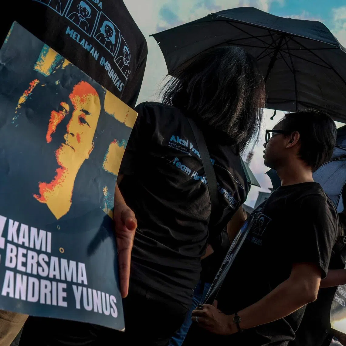 Activists hold black umbrellas and posters during a protest in front of the Presidential Palace in Jakarta on April 30.