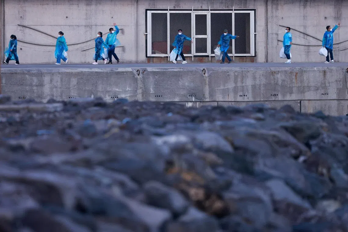 Tourists walking away after disembarking from the cruise ship MV Hondius, which was affected by a hantavirus outbreak, docked at the port of Granadilla de Abona, Tenerife, Spain on May 11, 2026. 
