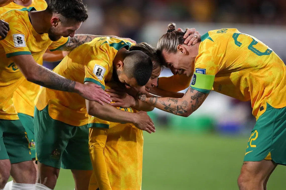 Craig Goodwin of Australia celebrates with teammates after scoring in the World Cup qualifier against China.