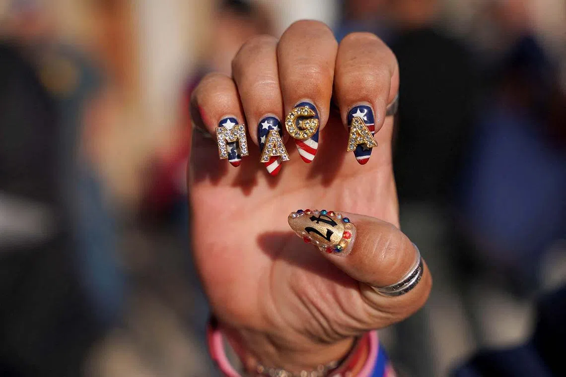 A supporter of Republican presidential nominee former U.S. President Donald Trump shows her "Make America Great Again" (MAGA) themed decorated nails outside the venue on the day of a campaign rally in Pittsburgh, Pennsylvania, U.S., November 4, 2024. REUTERS/Seth Herald TPX IMAGES OF THE DAY