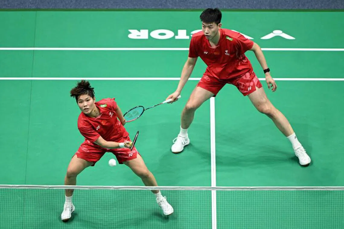 China's Feng Yanzhe (R) and Huang Dongping play a point during the mixed doubles quarterfinal match against Japan's Hiroki Midorikawa and Natsu Saito at the Badminton Asia Championships in Ningbo, in China's eastern Zhejiang Province on April 11, 2025. (Photo by STRINGER / AFP) / China OUT
